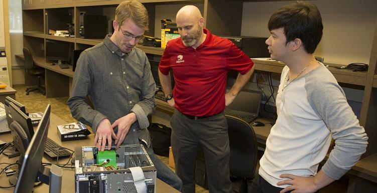 South students Thanh Nguyen, left, and Joel Dawson, right, meet with Dr. Todd Andel, associate professor of computing and principal investigator for a $4.1 million grant awarded to the School of Computing.